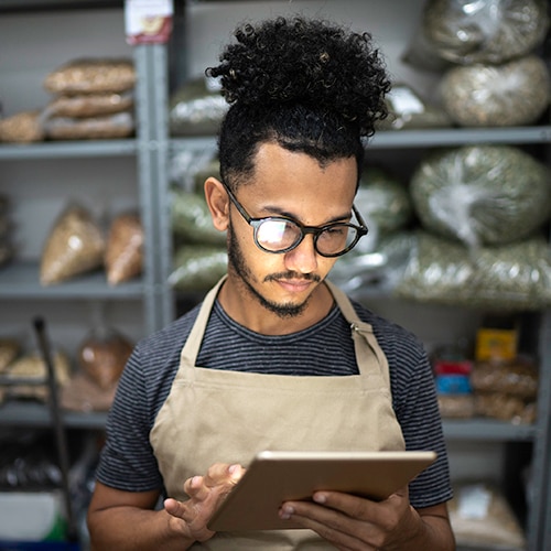 Men using digital tablet in storage room of a natural product shop